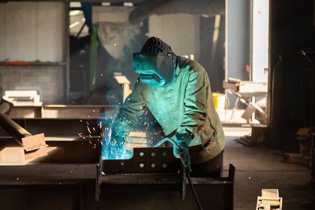 Welder in workshop with blue flame